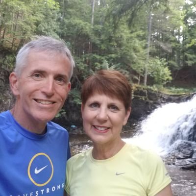 image of keith meyers and his wife with a waterfall in the background